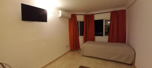 1 dormitorio con 1 cama y TV en la pared en Departamentos Centro Dpto 6 1 habitacion en Tandil