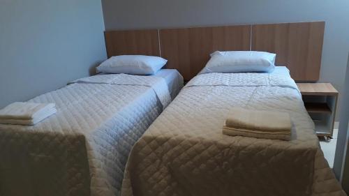 - 2 lits dans une chambre d'hôtel avec des serviettes dans l'établissement Pousada Recanto Gentil, à Triunfo