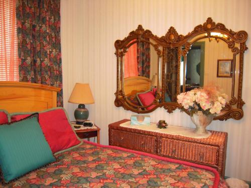 a bedroom with a bed and a large mirror at L'Arvidienne Couette et Café in Quebec City