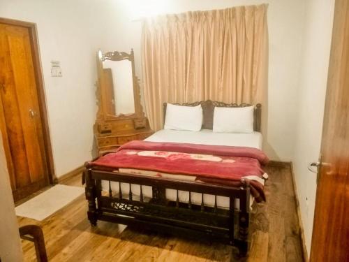een slaapkamer met een bed met een spiegel en een deur bij Glenfall Guest in Nuwara Eliya