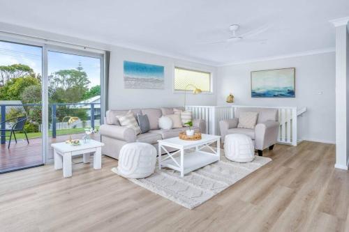 a living room with a couch and a table at Family Tides - Old Bar Holiday Rentals in Old Bar