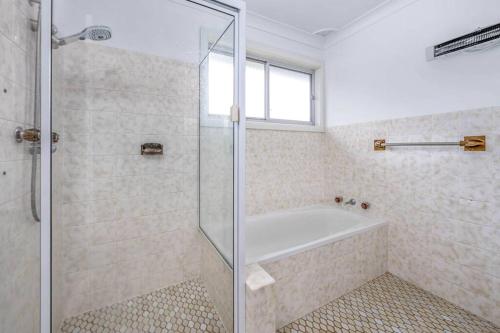 a bathroom with a shower and a bath tub at Family Tides - Old Bar Holiday Rentals in Old Bar