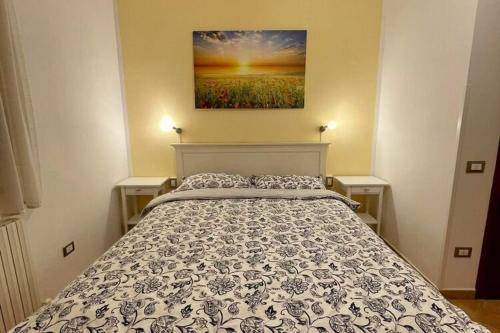 un letto in una camera da letto con un dipinto sul muro di Belvilla by OYO Landman Apartment a Larciano