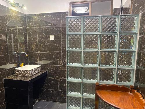 a bathroom with a glass block wall with wine bottles at Villa Blue Lagoon in Sihanoukville