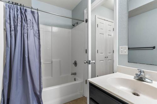 a white bathroom with a sink and a shower at King Bed, Garage, Free Parking, Large Backyard 3BR 2B in Manhattan