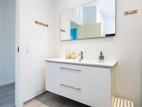 a white bathroom with a sink and a mirror at Holiday home Sjølund XXII in Sjølund