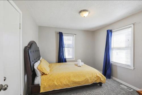 a bedroom with a bed with blue curtains at Beautiful Getwaway, Big Back Yard, Great Deck KSQ5614 in Shawnee