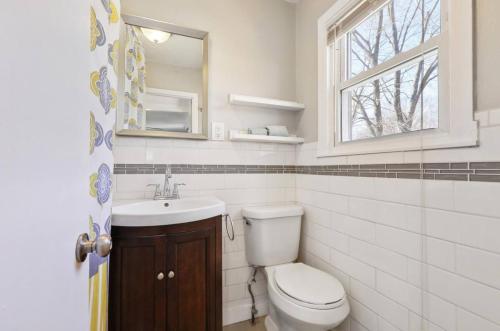 a bathroom with a toilet and a sink and a window at Beautiful Getwaway, Big Back Yard, Great Deck KSQ5614 in Shawnee