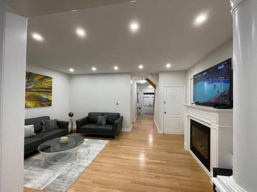 a living room with a couch and a tv on a fireplace at Luxury 4-Bedrooms Home… in Brampton
