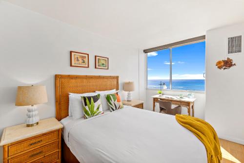 a bedroom with a bed with a view of the ocean at Ilikai Marina 1BR Condo, Ocean View Haven in Honolulu