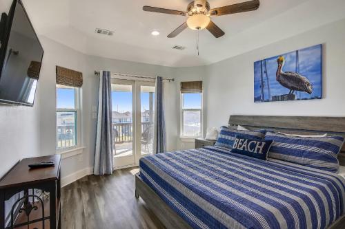 een slaapkamer met een bed en een plafondventilator bij Seaward Breeze in Galveston