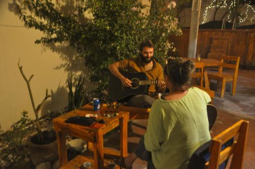 a man playing a guitar next to a woman at Sunset Hostel - Centro - in La Paz