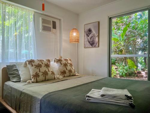 a bedroom with a bed with a large window at Jikinerita Homestay in Nelly Bay