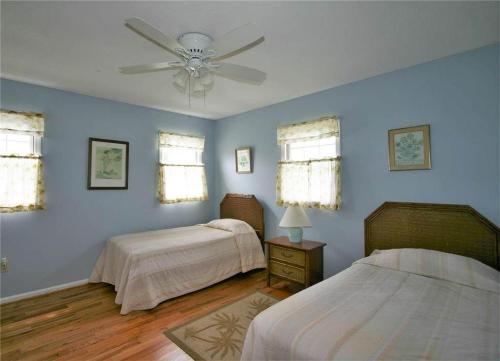 a bedroom with two beds and a ceiling fan at Belvedere in Edisto Island