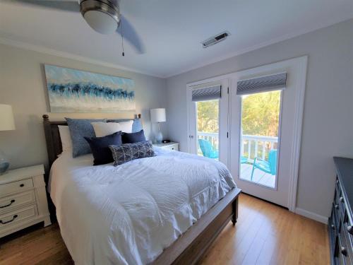 ein Schlafzimmer mit einem Bett und einem Balkon in der Unterkunft Gone Coastal in Edisto Island