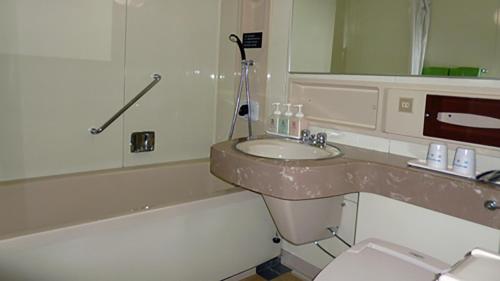 a bathroom with a sink and a toilet and a bath tub at Honjo Grand Hotel Vacation STAY 35750 in Yurihonjo