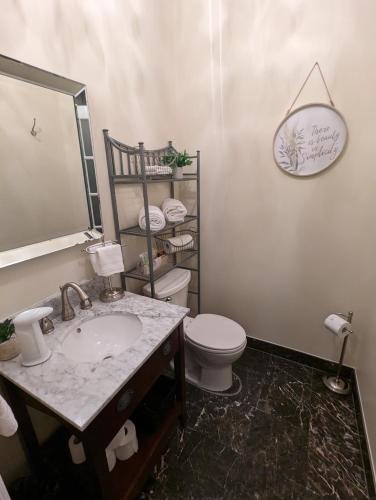 a bathroom with a sink and a toilet and a mirror at Suites On King in Niagara on the Lake