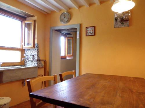 una sala da pranzo con tavolo e orologio sul muro di Belvilla by OYO characteristic Tuscan flat a Lucchio
