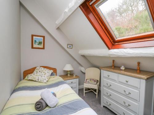 a attic bedroom with two beds and a window at Tanyrallt Farm in Beulah