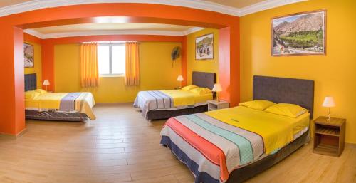Habitación amarilla con 2 camas. en Hotel Savilayo en Ica