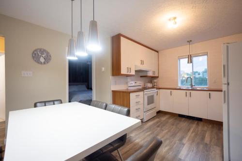 a kitchen with a white table and chairs in a room at Le Contemporain in Rouyn