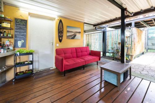 a living room with a red couch and a table at KIA ORA Lodge in Afaahiti