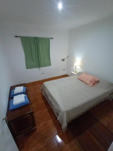 1 dormitorio con cama, mesa y ventana en Departamento Piccolo en Las Flores