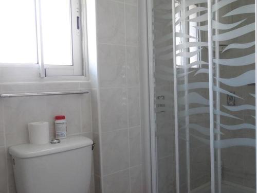 une salle de bain blanche avec toilettes et fenêtre dans l'établissement Maison Centre Village, Proche Plage, 3 Chambres, Jardin Clos, Idéale Sans Voiture - FR-1-476-156, à La Faute-sur-Mer