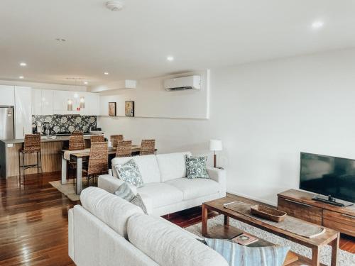 a living room with a couch and a table at Byron Butter Factory Apartments in Byron Bay