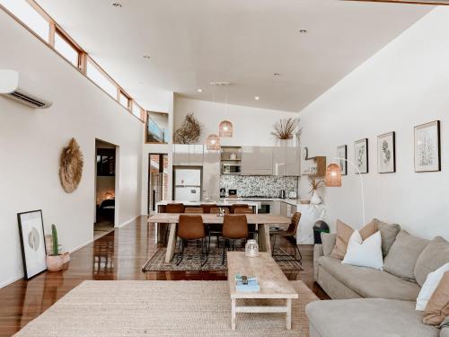 a living room with a couch and a table at Byron Butter Factory Apartments in Byron Bay