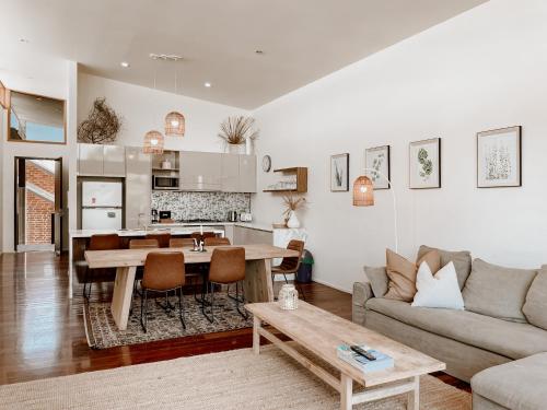 a living room with a couch and a table at Byron Butter Factory Apartments in Byron Bay