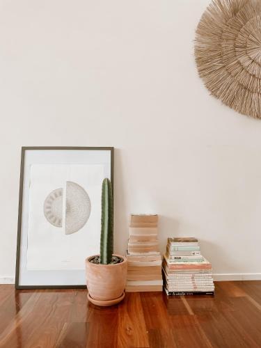 a cactus and books in a room with a picture at Byron Butter Factory Apartments in Byron Bay