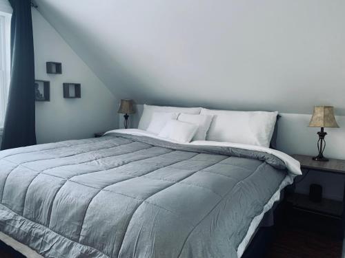 ein Schlafzimmer mit einem großen Bett mit weißer Bettwäsche in der Unterkunft Gorgeous house by the lake in Timmins