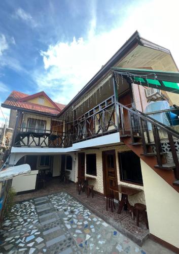 - Edificio con balcón y patio en Lola Flor's Guest House en El Nido