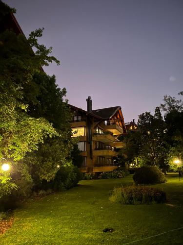 a large building at night with a green yard at Departamento Pucon in Pucón