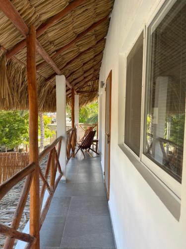a porch of a house with a straw roof at Casa OM in El Cuyo