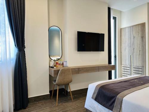a bedroom with a bed and a mirror and a tv at LION 5 HOTEL in Can Tho