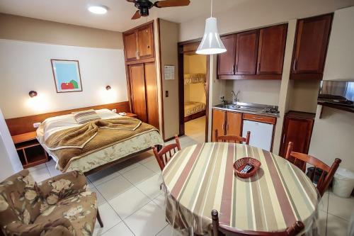 a room with a bed and a table and chairs at Pousada do Serrano - Rua Torta in Gramado