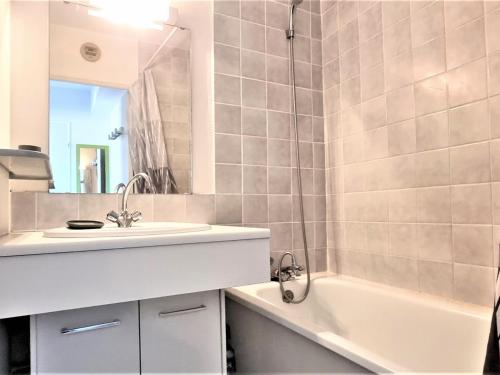a bathroom with a sink and a tub and a mirror at Appartement Cerbère, 2 pièces, 4 personnes - FR-1-309-361 in Cerbère