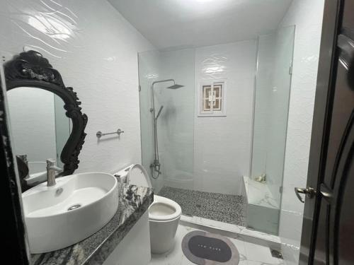 ein weißes Bad mit einem Waschbecken und einer Dusche in der Unterkunft New build beautiful Apartment in Dagupan