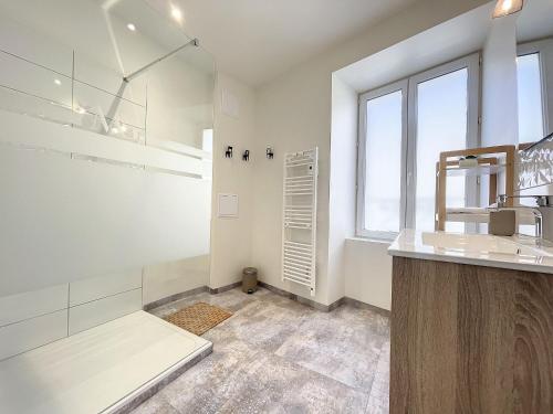un bagno bianco con un lavandino e una finestra di Gîte confortable à Saugues pour randonneurs, 3 chambres spacieuses avec salle d'eau privative - FR-1-582-365 a Cubelles