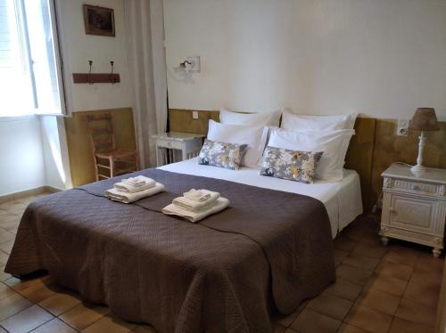 a bedroom with a large bed with towels on it at Le Petit Fabre in Montagnac