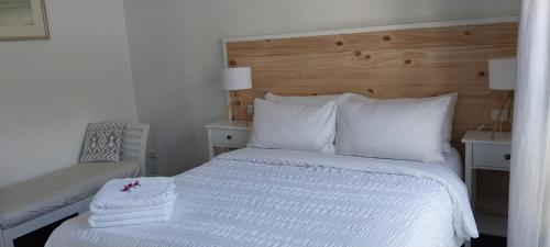 a bedroom with a bed with white sheets and pillows at Maple Villa - The Beach House by the bay in Brisbane