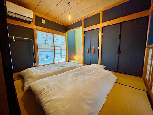 1 dormitorio con 2 camas en una habitación en 旅籠屋ゆいまーる en Mameda-shimmachi