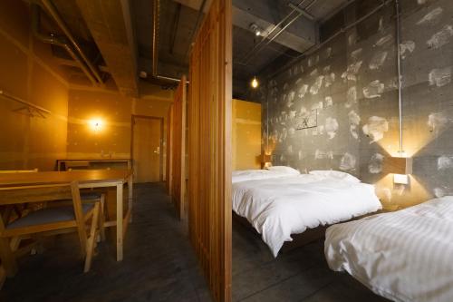 a room with two beds and a table and a dining room at Yoichi LOOP in Kurokawamachi