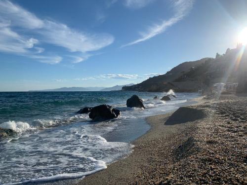 a beach with rocks and the ocean on a sunny day at Mono Ele a Varigotti in Varigotti