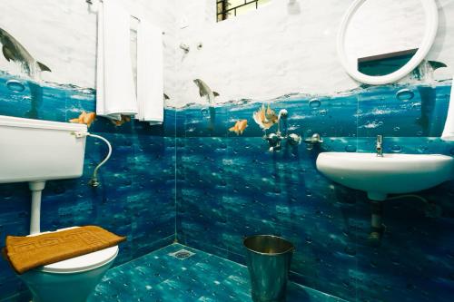 a bathroom with a fish mural on the wall at Jolene's Ashvem in Mandrem
