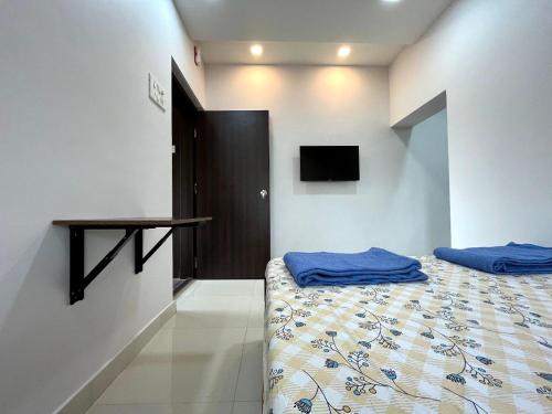 a bedroom with a bed with blue sheets and a table at Gayatri Homestay in Ratnagiri