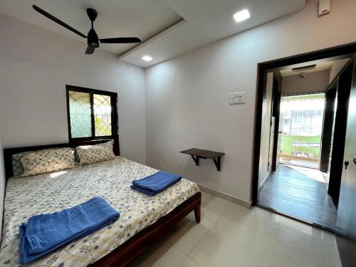 um quarto com uma cama com toalhas azuis em Gayatri Homestay em Ratnagiri
