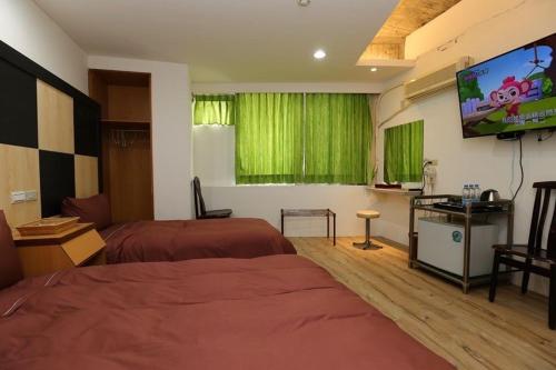 信義鄉的住宿－玉山樓民宿，酒店客房设有两张床和一台平面电视。